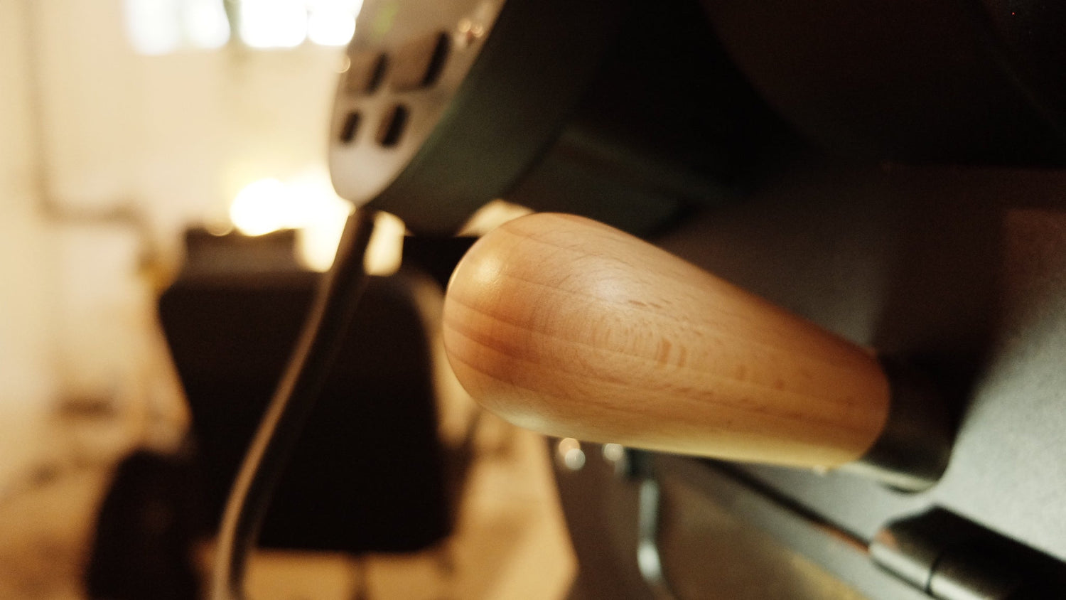 Kleiner Röster, mit hellem Holzgriff, verschwommener Hintergrund.