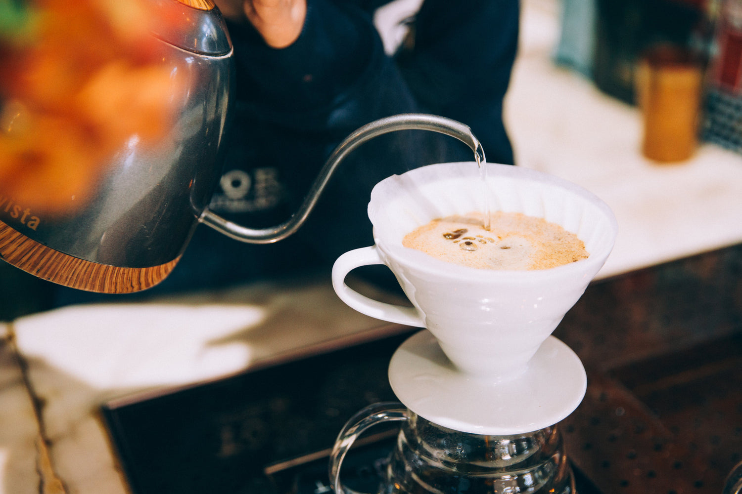 Keramik V60 Filterhalter, Silberner Wasserkocher gießt Wasser auf Kaffee.